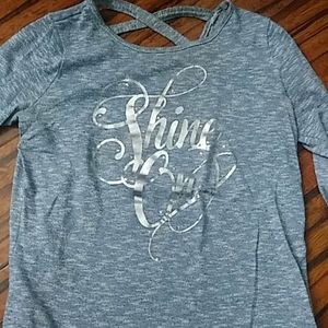 A blue long sleeve shirt with "shine out " on it